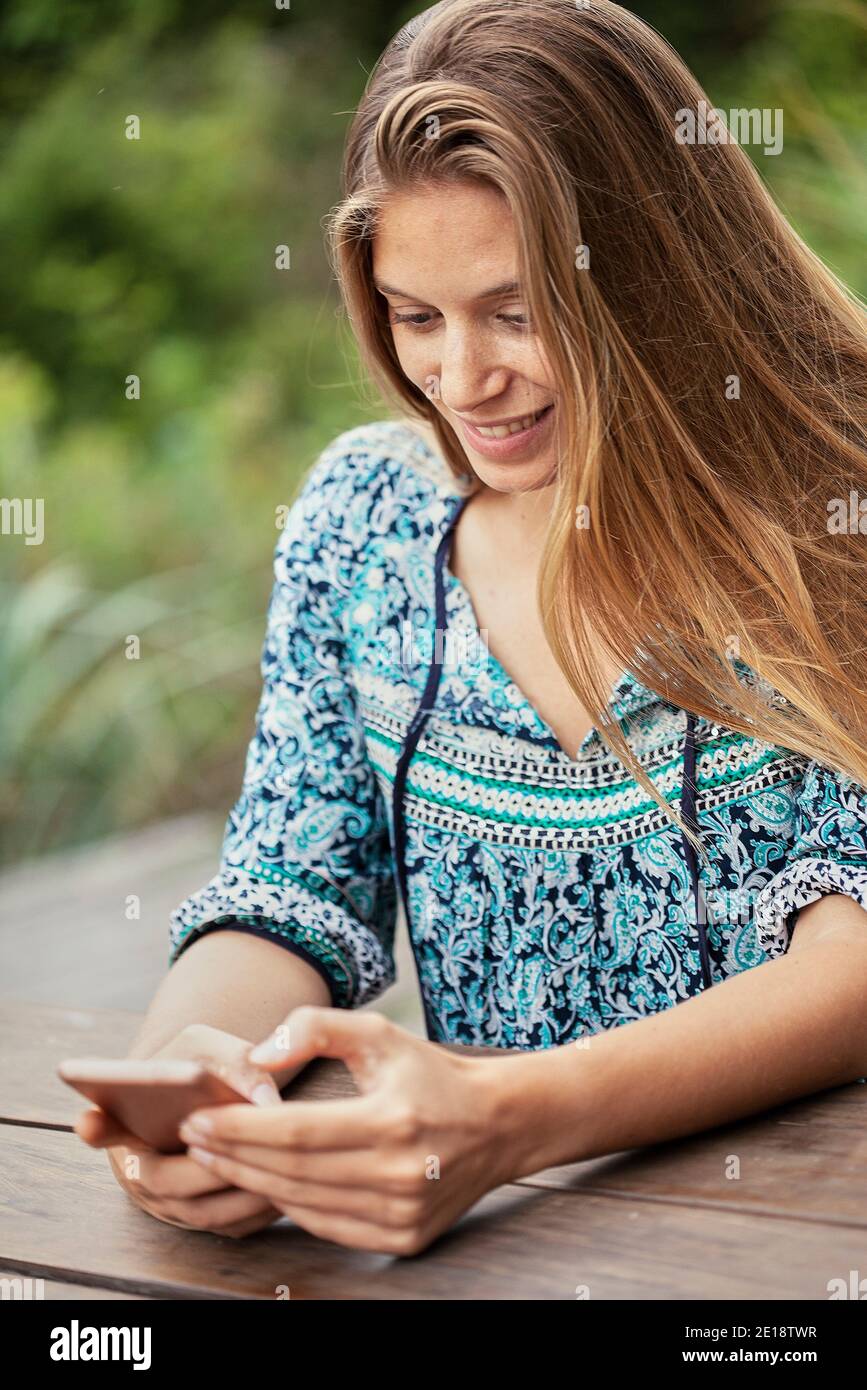 Smiling mid adult woman using smartphone Stock Photo