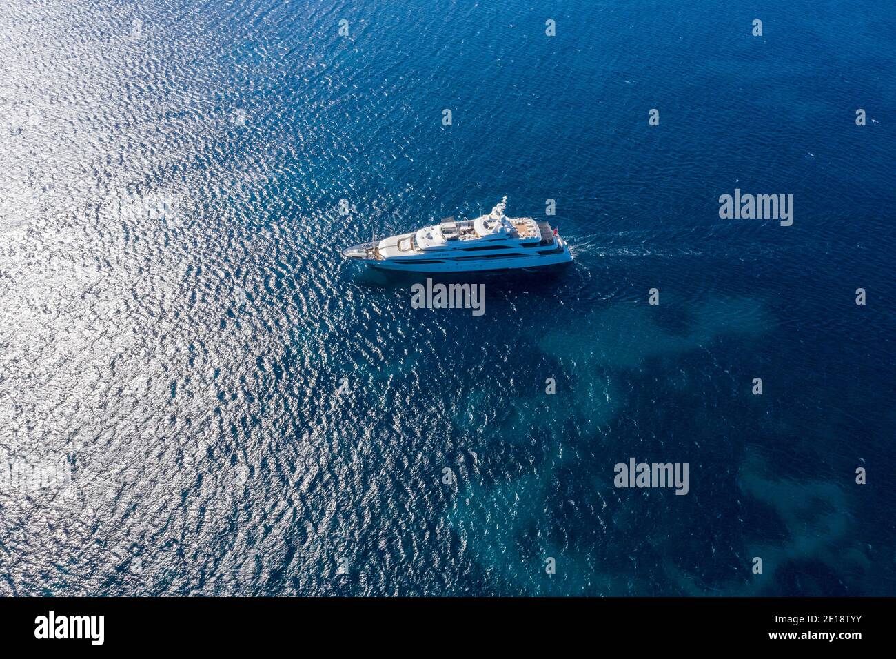 A superyacht sailing in the Mediterranean sea, from above. Stock Photo