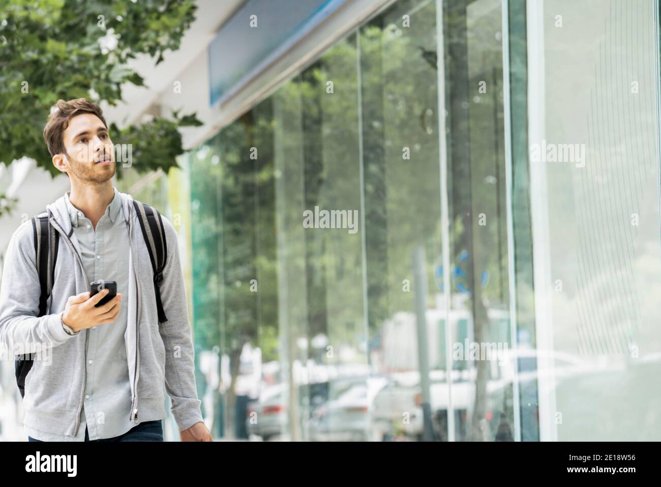 One young man backpack mobile hi-res stock photography and images - Alamy