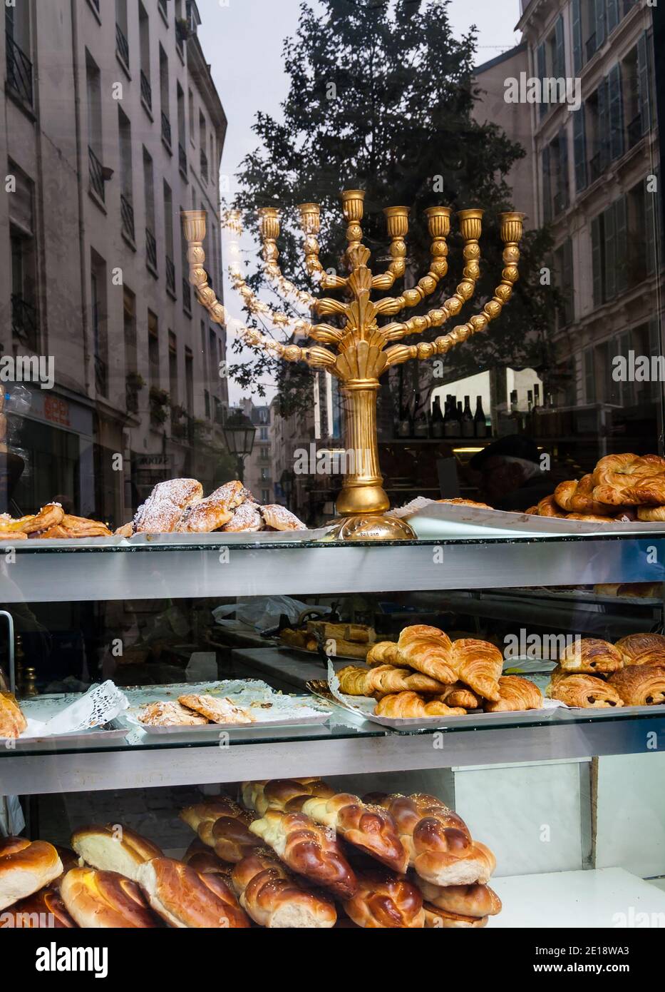 Menorah in the window of a kosher bakery in Marais (Paris). Reflection