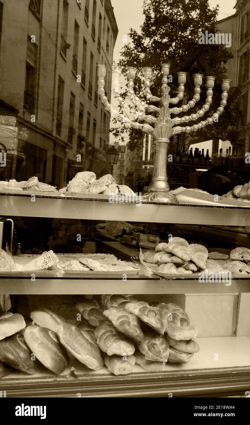 Menorah in the window of a kosher bakery in Marais (Paris). Reflection