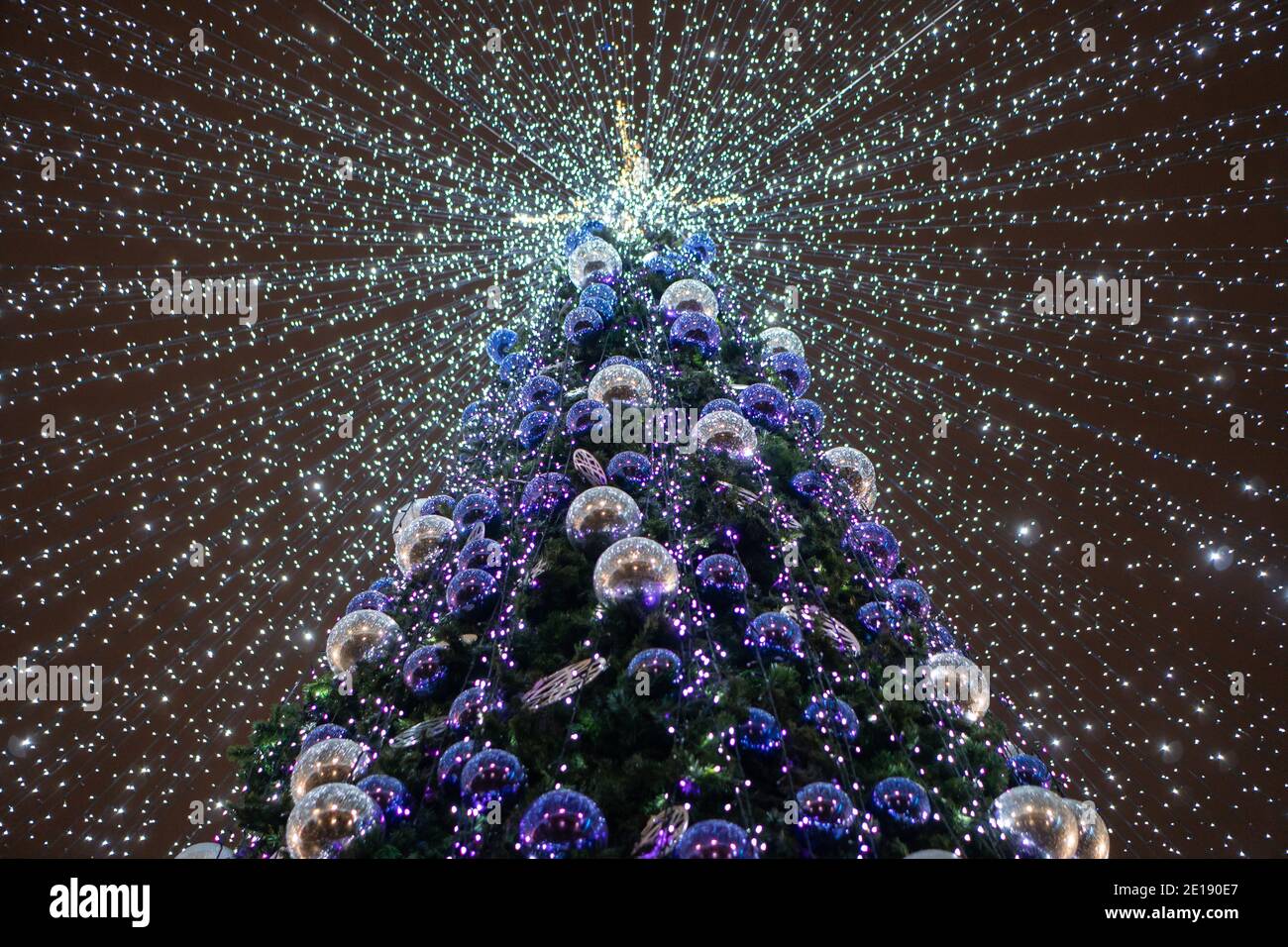 Street Christmas tree decorated with garlands and balloons bottom view ...