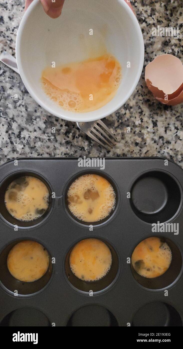 Beated egg in a muffin tray Stock Photo