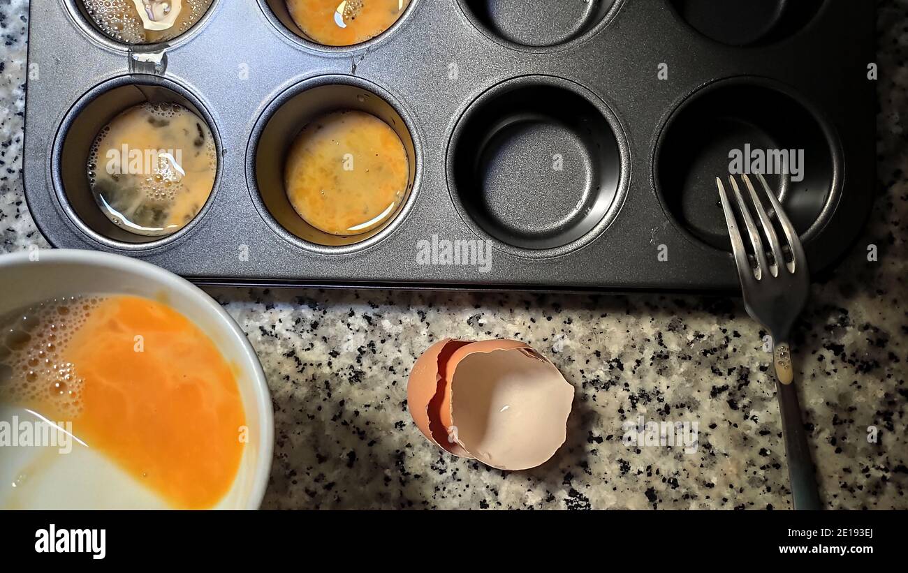 Beated egg in a muffin tray Stock Photo