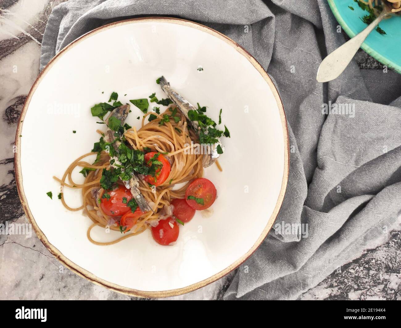 Italian pasta bowls with sardines, cherry tomatoes and fresh persil Stock Photo