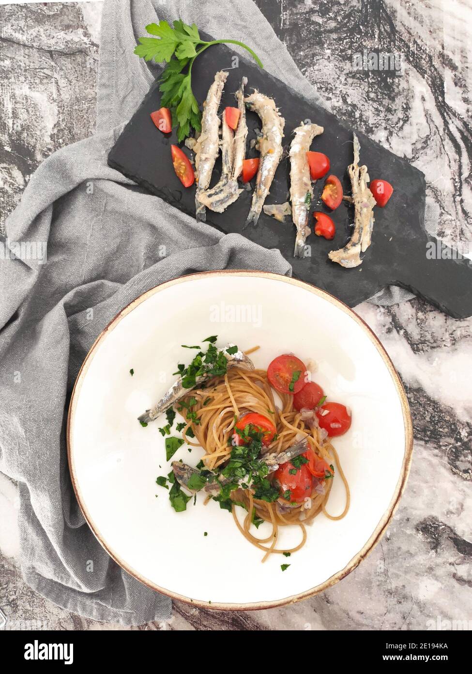 Italian pasta bowls with sardines, cherry tomatoes and fresh persil Stock Photo