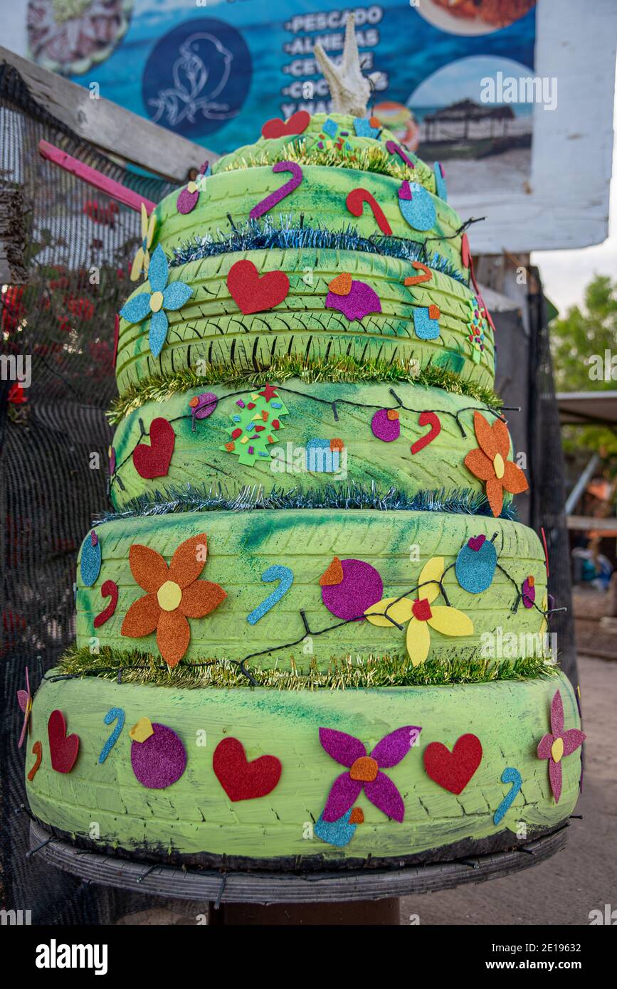 A Christmas tree made from car tires that have been painted green and decorated with candy canes, hearts and flowers cut from colorful papers. Stock Photo