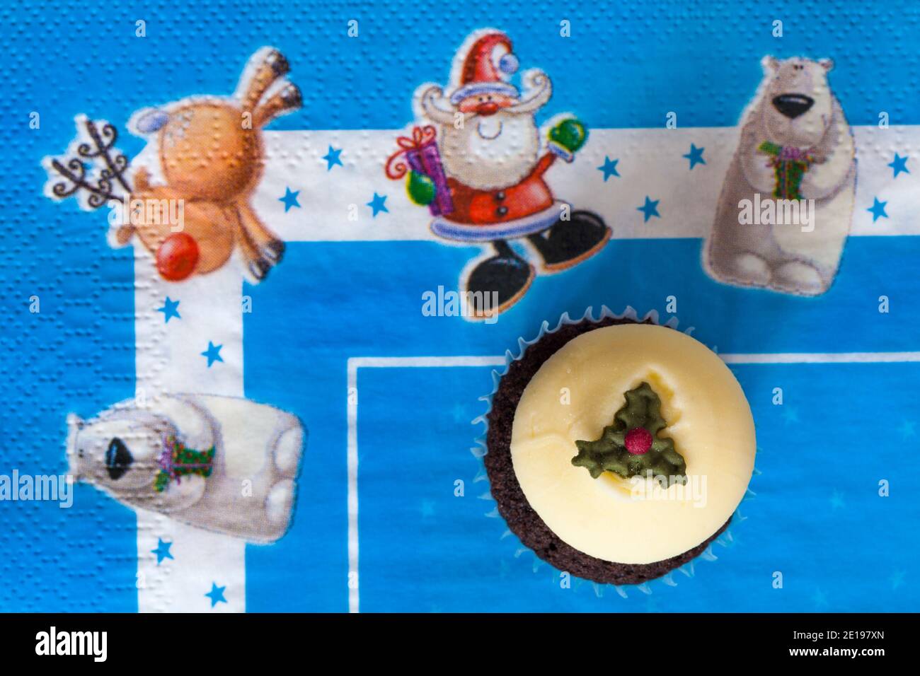 Christmas pudding cupcake cup cake from box of M&S 9 mini festive cupcakes set on Christmas serviette napkin Xmas Stock Photo