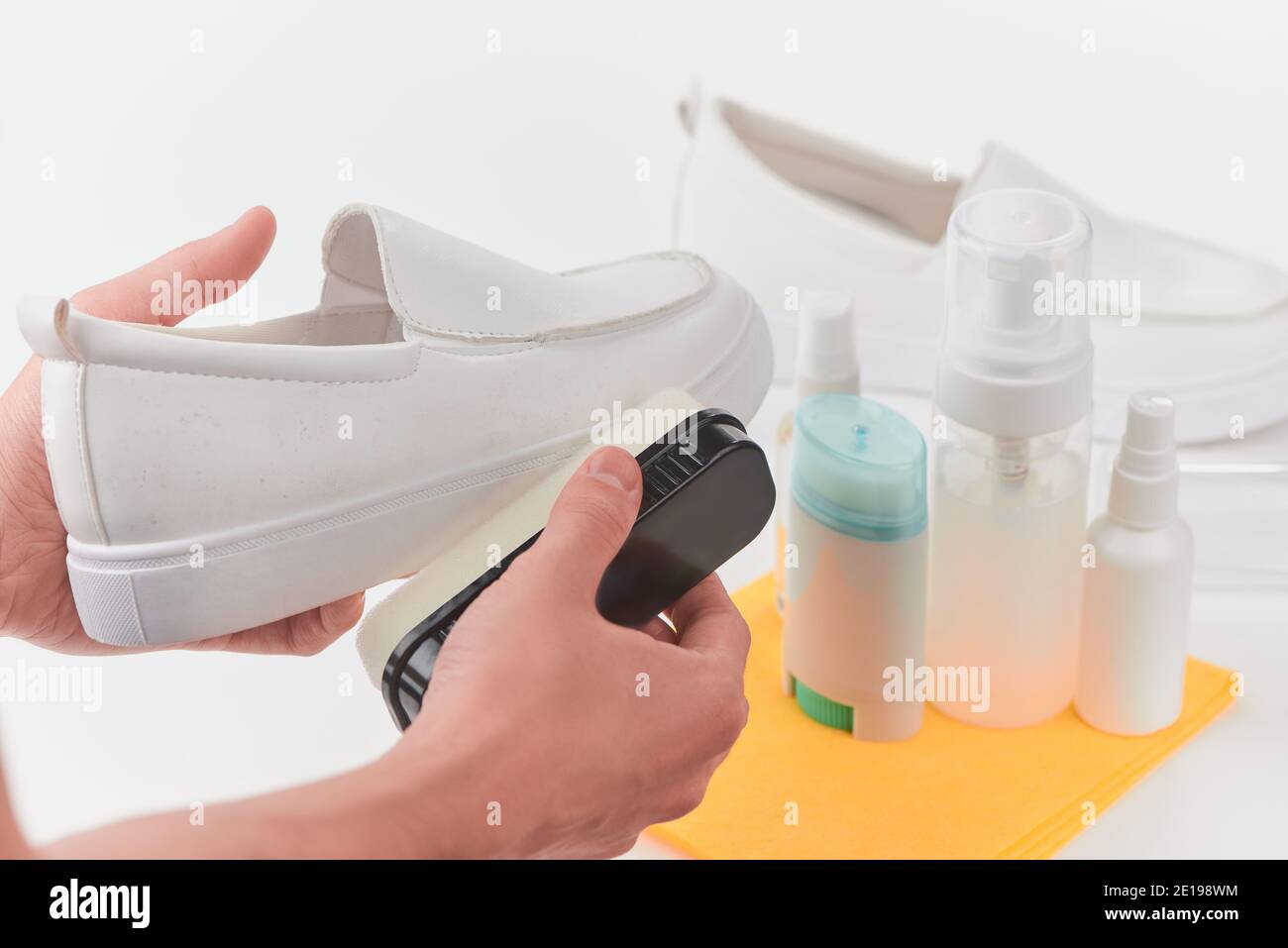 Hands removing dust and dirt from a white leather loafer using a sponge Stock Photo Alamy