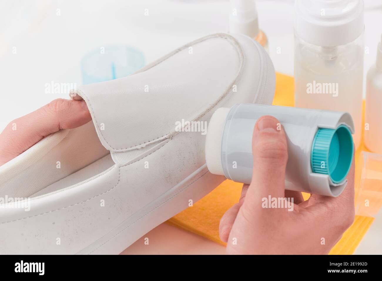 Hand removing dirt from a white leather loafer using a sponge detergent Stock Photo Alamy