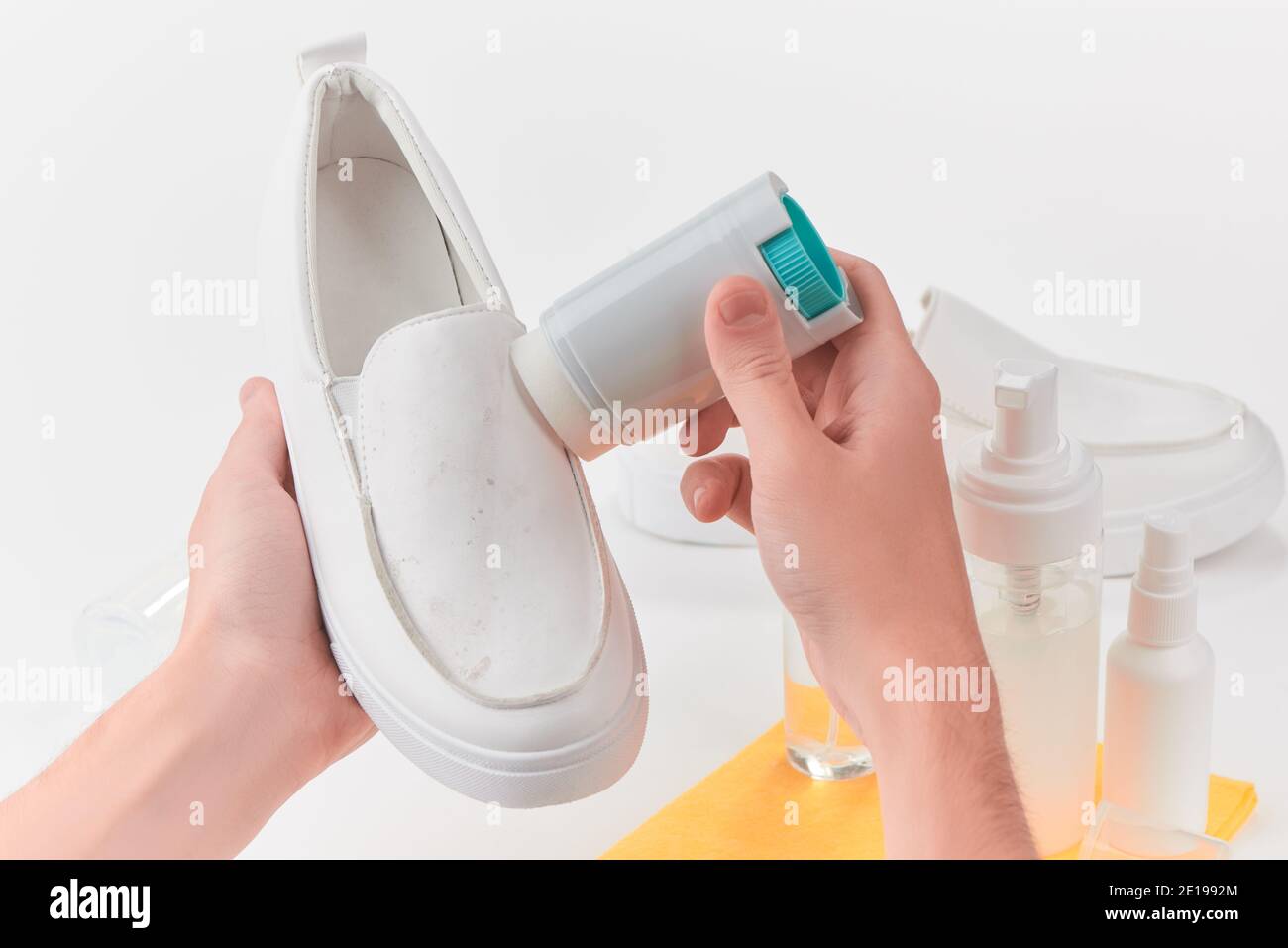 Man removing dirt and dust from a white leather slipon shoe Stock Photo Alamy