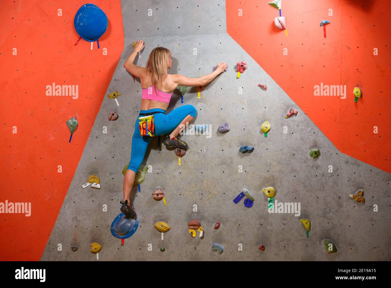 Climbing Gym. Young Woman Climber Bouldering. Extreme Sport and Indoor Climbing Concept Stock Photo