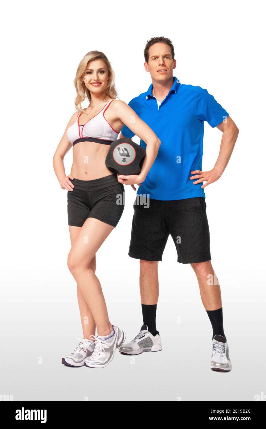 Portrait of a fit, white coach & female athlete with curly long blond hair posing together holding a medicine ball in a studio with white background. Stock Photo