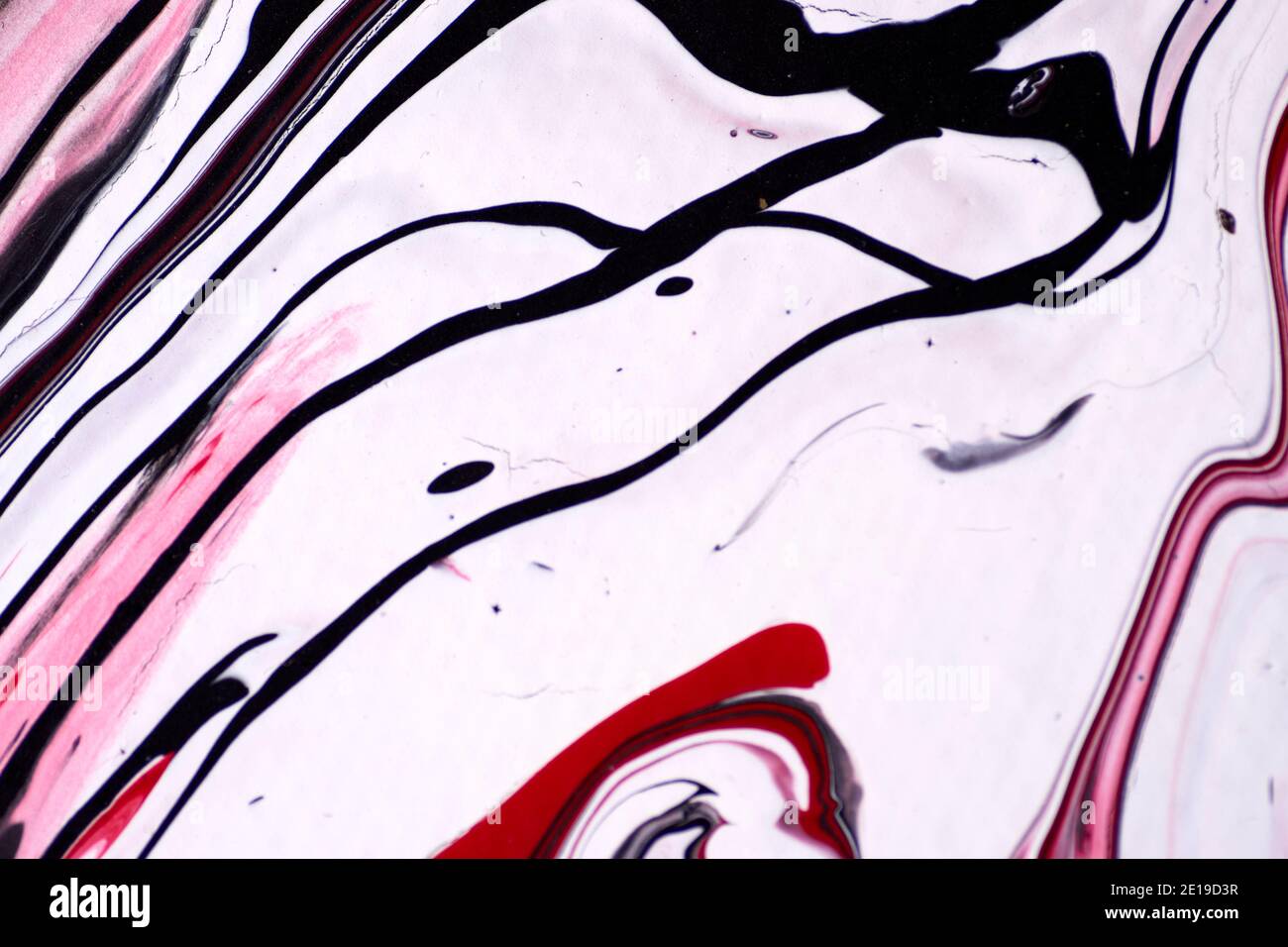 Marbled acrylic colored pattern in the colors red, black, white and pink Stock Photo