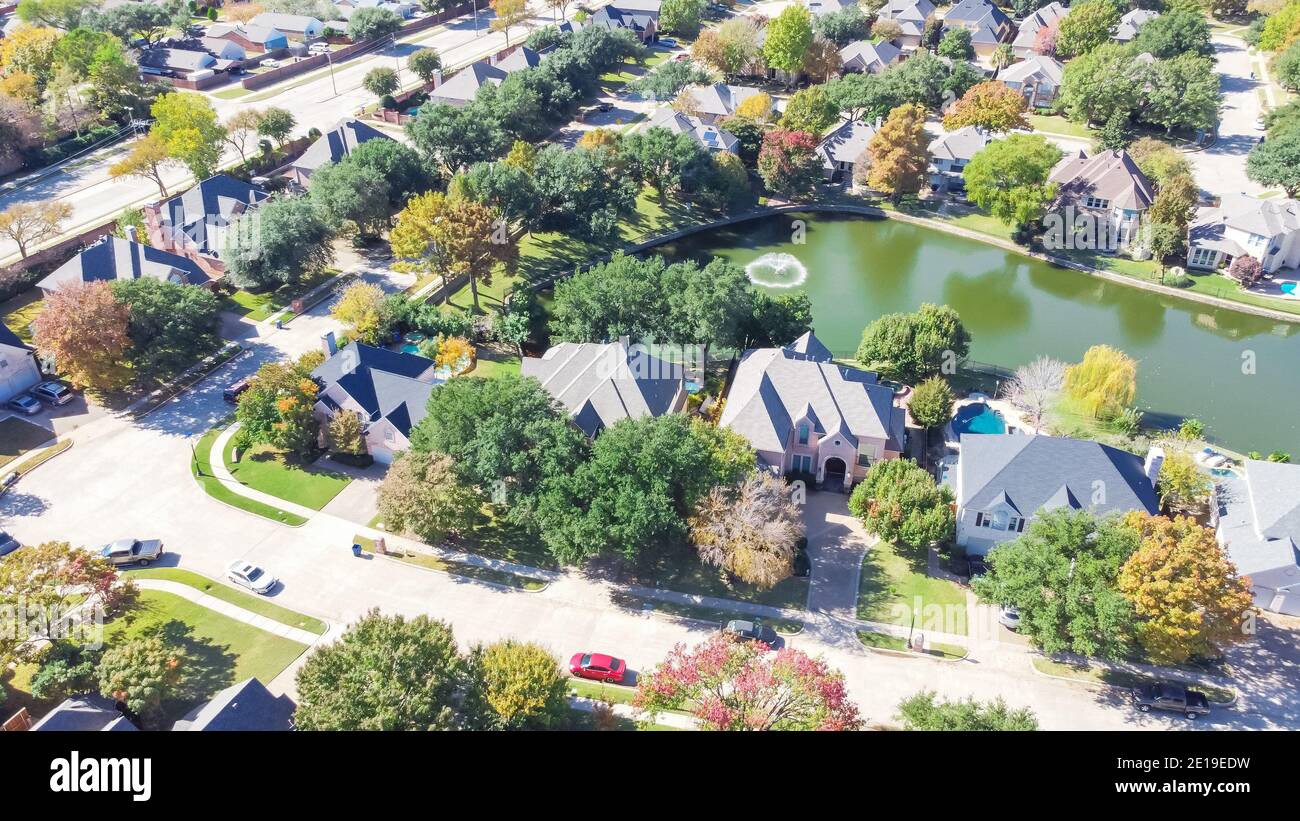 Lakeside houses with water fountain and colorful fall foliage in