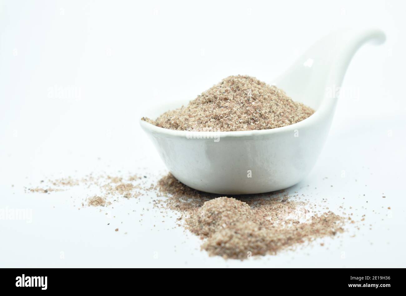 Himalayan black salt or volcanic rock salt on spoon in white background