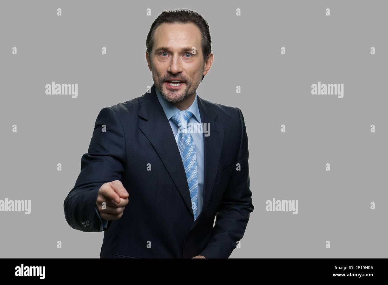 Aggressive businessman shouting and pointing to camera. Stock Photo