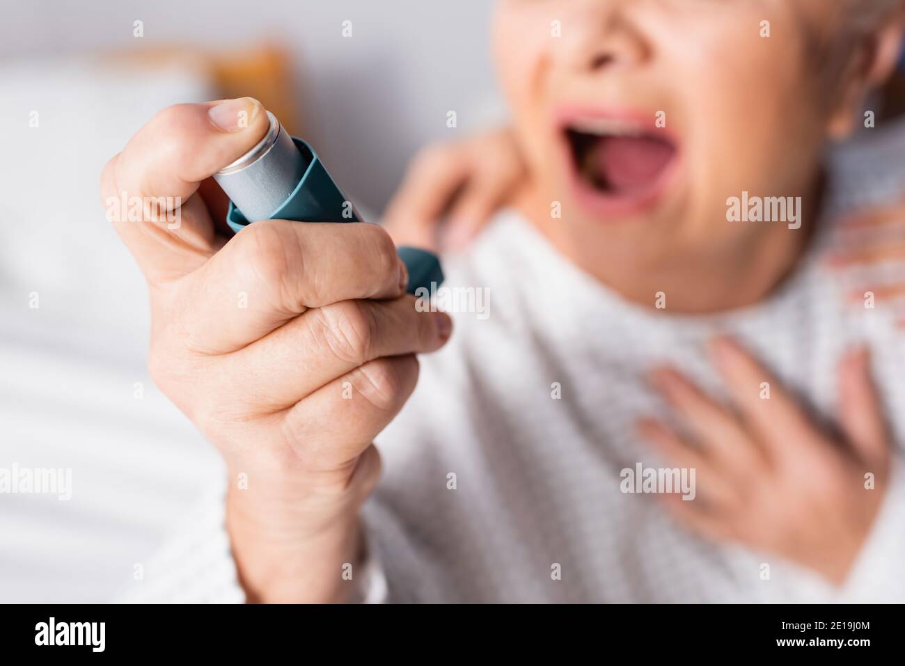 cropped view of senior woman with open mouth holding inhaler while  suffering from asthma attack, blurred background Stock Photo - Alamy