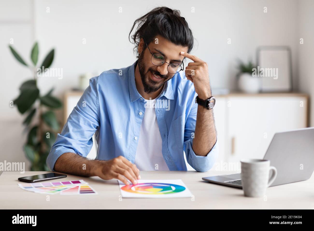 Cheerful Arab Freelance Designer Guy Working With Color Samples At Home Office Stock Photo