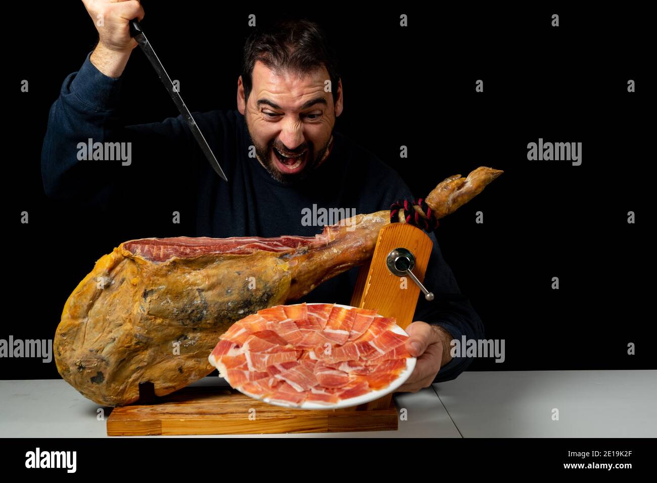 Bearded man with a ham knife ready to cut a piece of typical Spanish