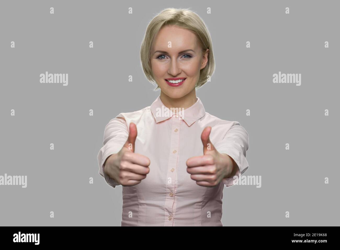 Business woman showing thumbs up to camera Stock Photo - Alamy