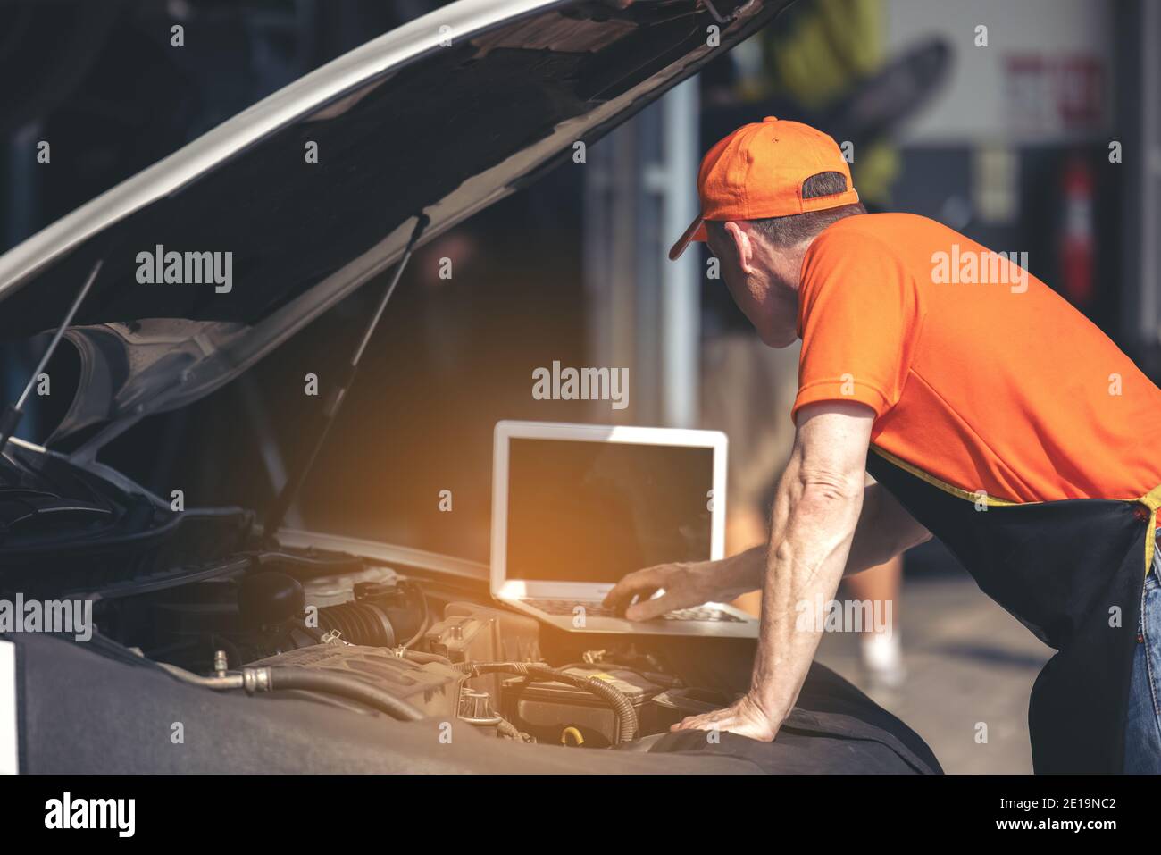 Car maintenance service, technician diagnose car engine failure problem by laptop computer. Stock Photo