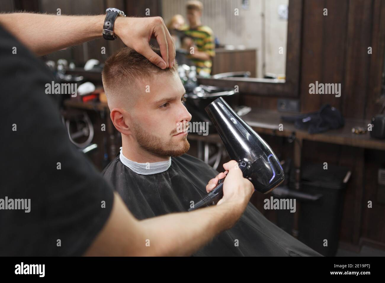 Close up of a man having his hair blow dried by professional barber Stock Photo