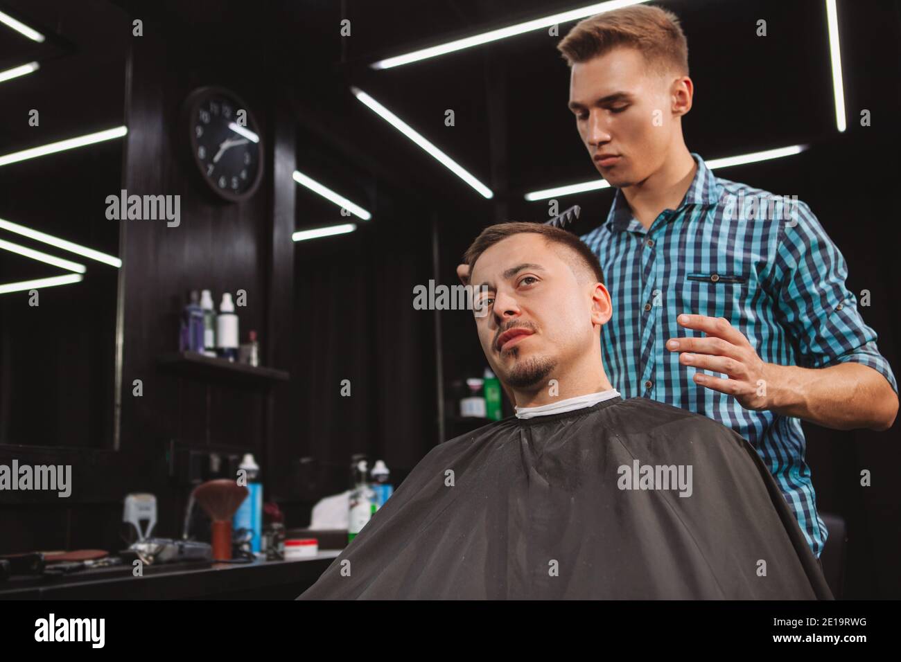 Low angle shot of a handsome mature man looking away thoughtfully while professional barber styling his hair, copy space. Hairstylist working with mal Stock Photo