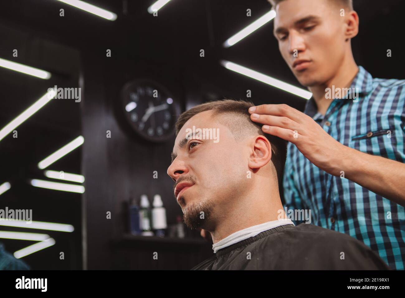 Cropped close up of a mature man getting a new hairstyle at the barbershop, copy space. Young barber styling hair of a male client. Professionalism, h Stock Photo