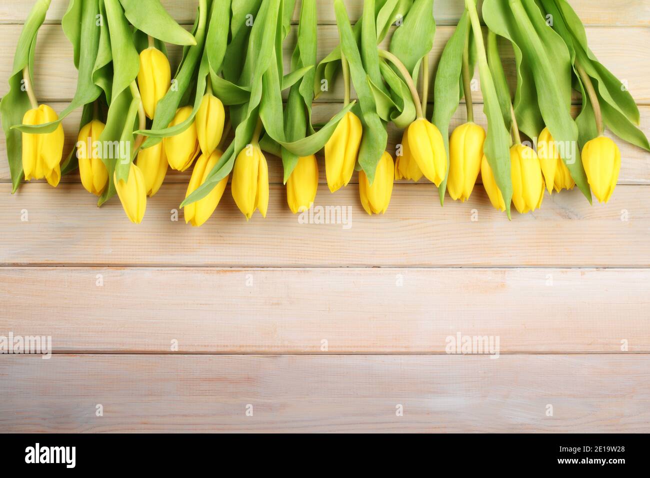 Easter background with yellow tulips on a wooden table Stock Photo