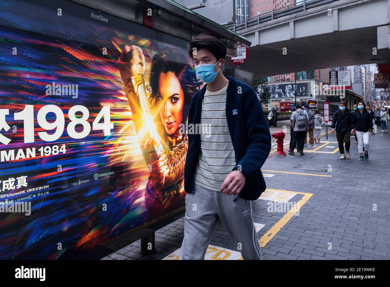 A pedestrian walks past an advertisement billboard from Warner Bros Official Site and DC comics character Wonder Woman 1984 movie in Hong Kong. Stock Photo