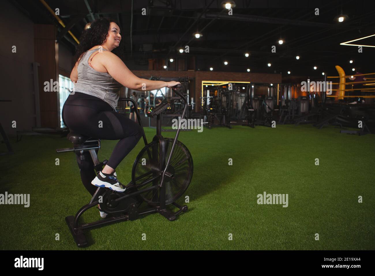 Rear view shot of a plus size sportswoman smiling, looking away