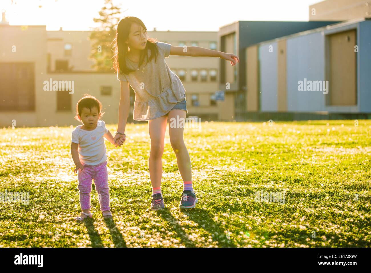 Longueuil, Canada - August 15 2020: Sisters hand in hand walking in the forest in a summer afternoon Stock Photo