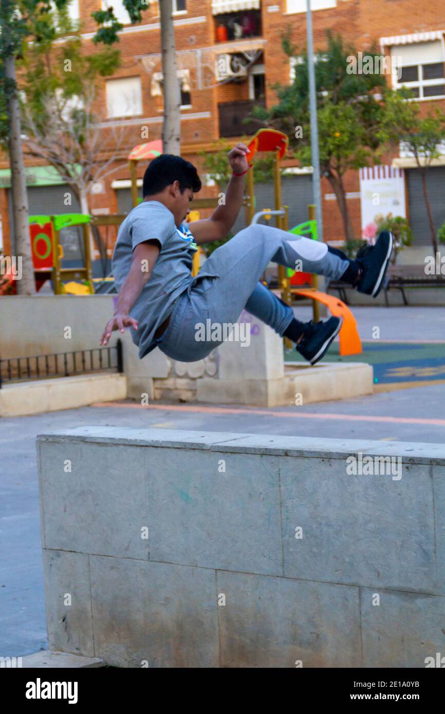 Active Latino young man jumping in action. Extreme sport activity, parkour outdoor free running or healthy lifestyle concept Stock Photo