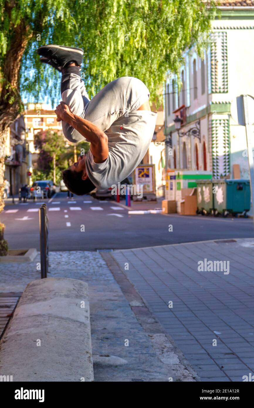 Active Latino young man jumping in action. Extreme sport activity, parkour outdoor free running or healthy lifestyle concept Stock Photo