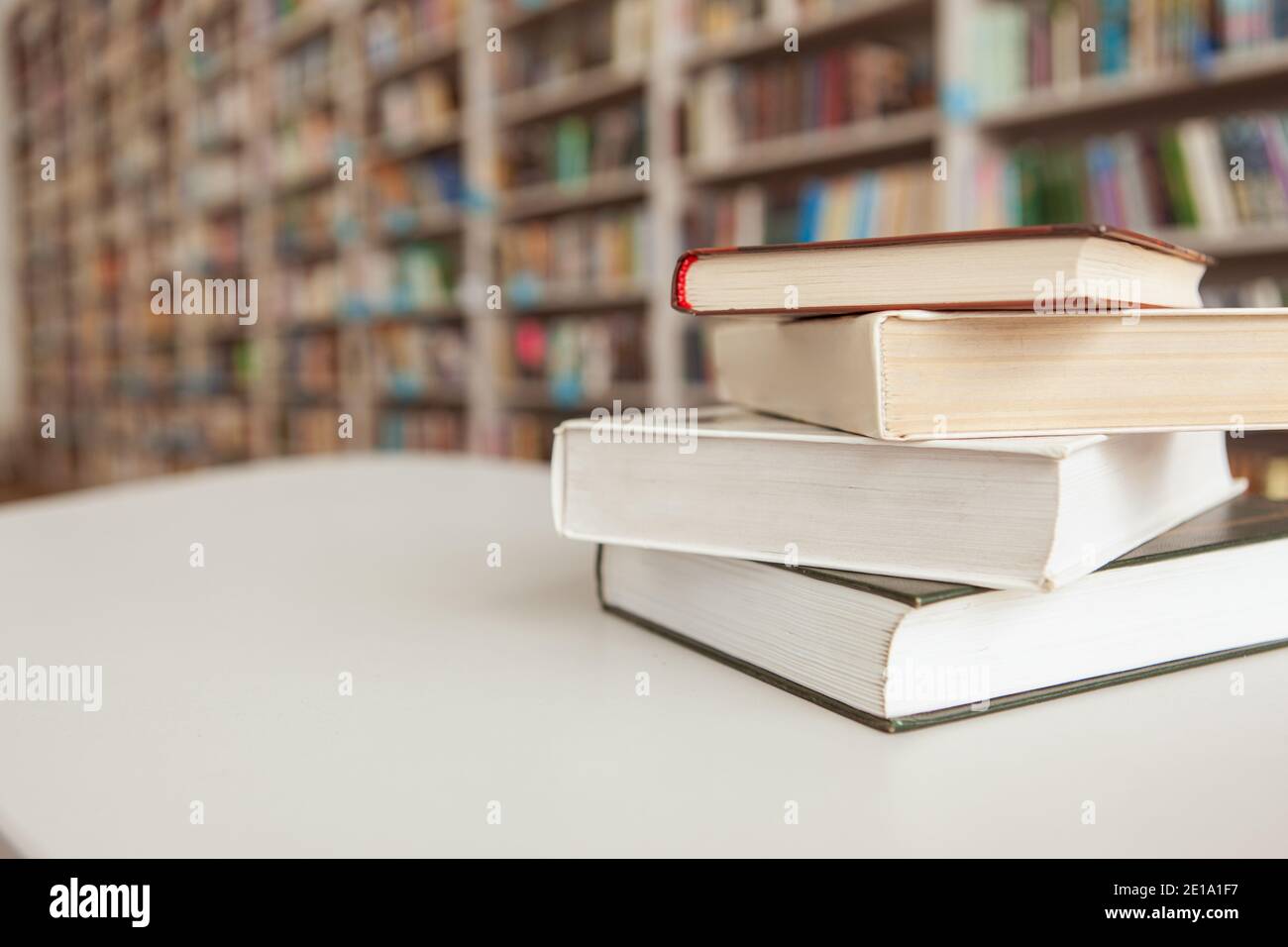 Close up of a book stack on the table, library bookshelves on