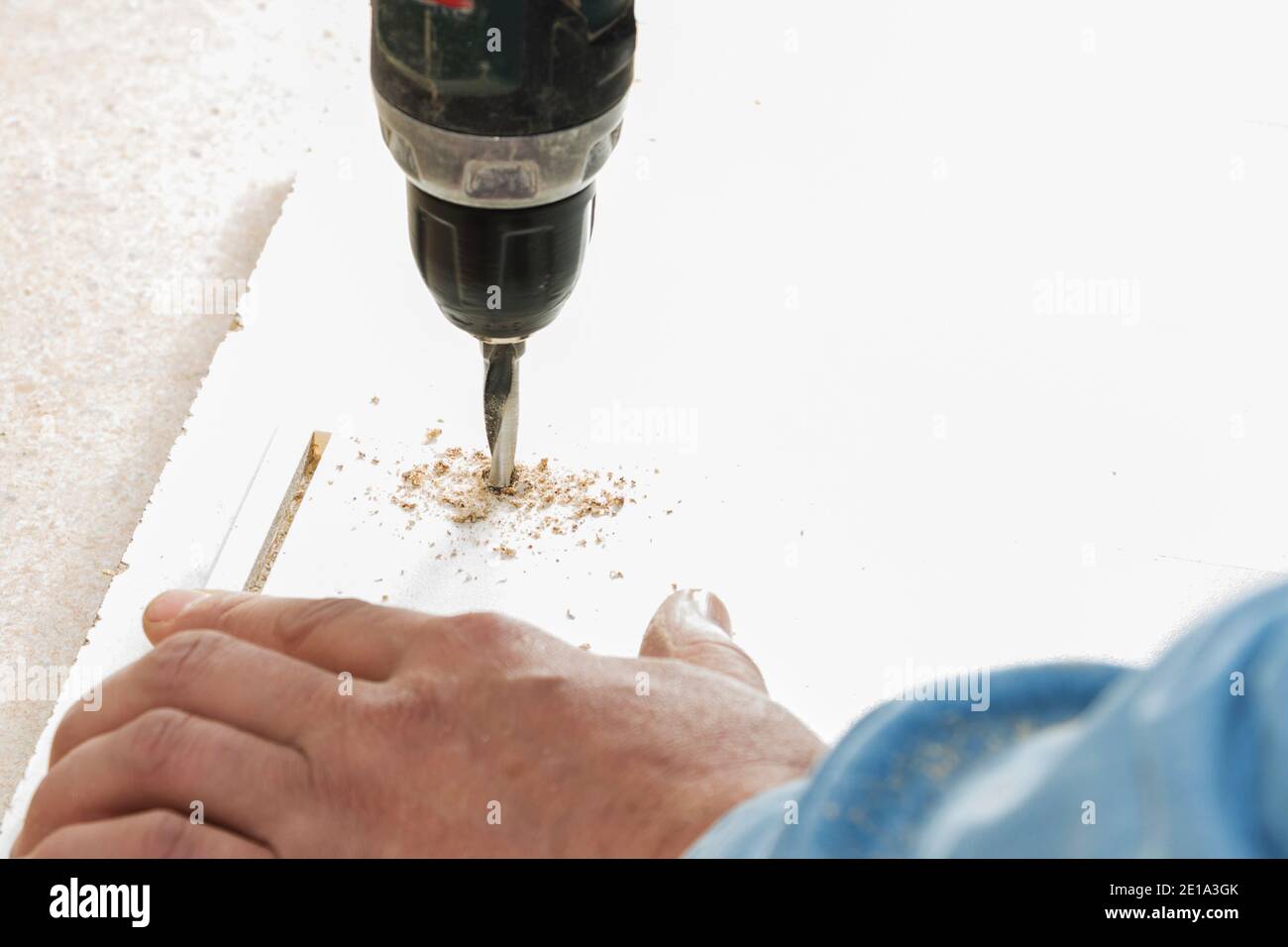 worker drills a hole when assembling furniture. Stock Photo