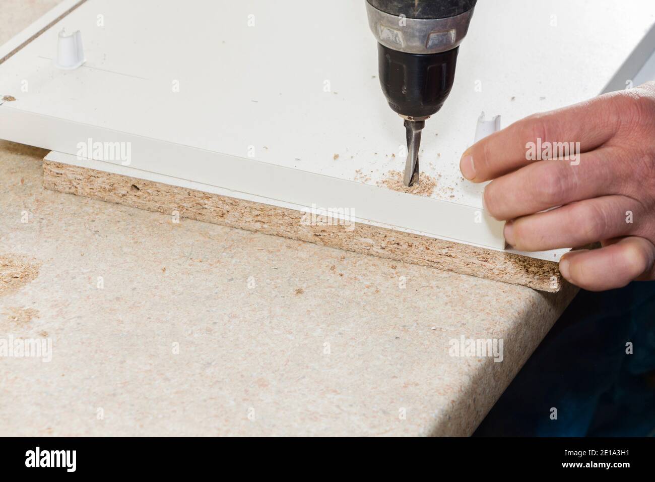 worker drills a hole when assembling furniture Stock Photo Alamy