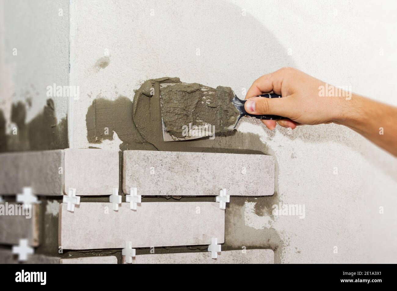 Laying Ceramic Tiles. The Builder makes repairs Stock Photo Alamy