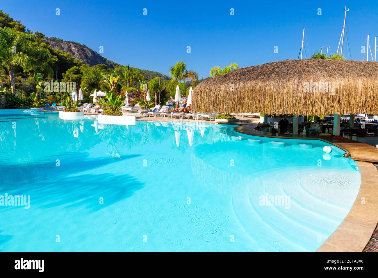Swimming pool and pool bar with straw tiki roof at luxury Yacht Classic Hotel, Ece Marina, Fethiye, Turkish Riviera, Turkey Stock Photo