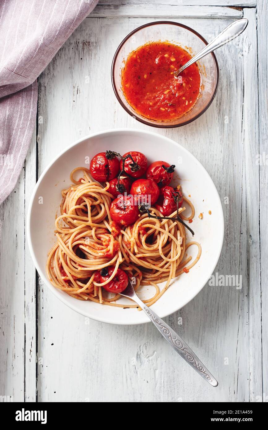 Spaghetti pasta with tomato sauce and roasted cherry tomatoes. Stock Photo
