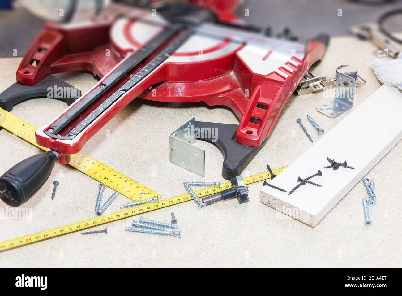 Carpenter workplace. Carpenter tools on wooden table with sawdust. Compound Mitre Saw cutting
