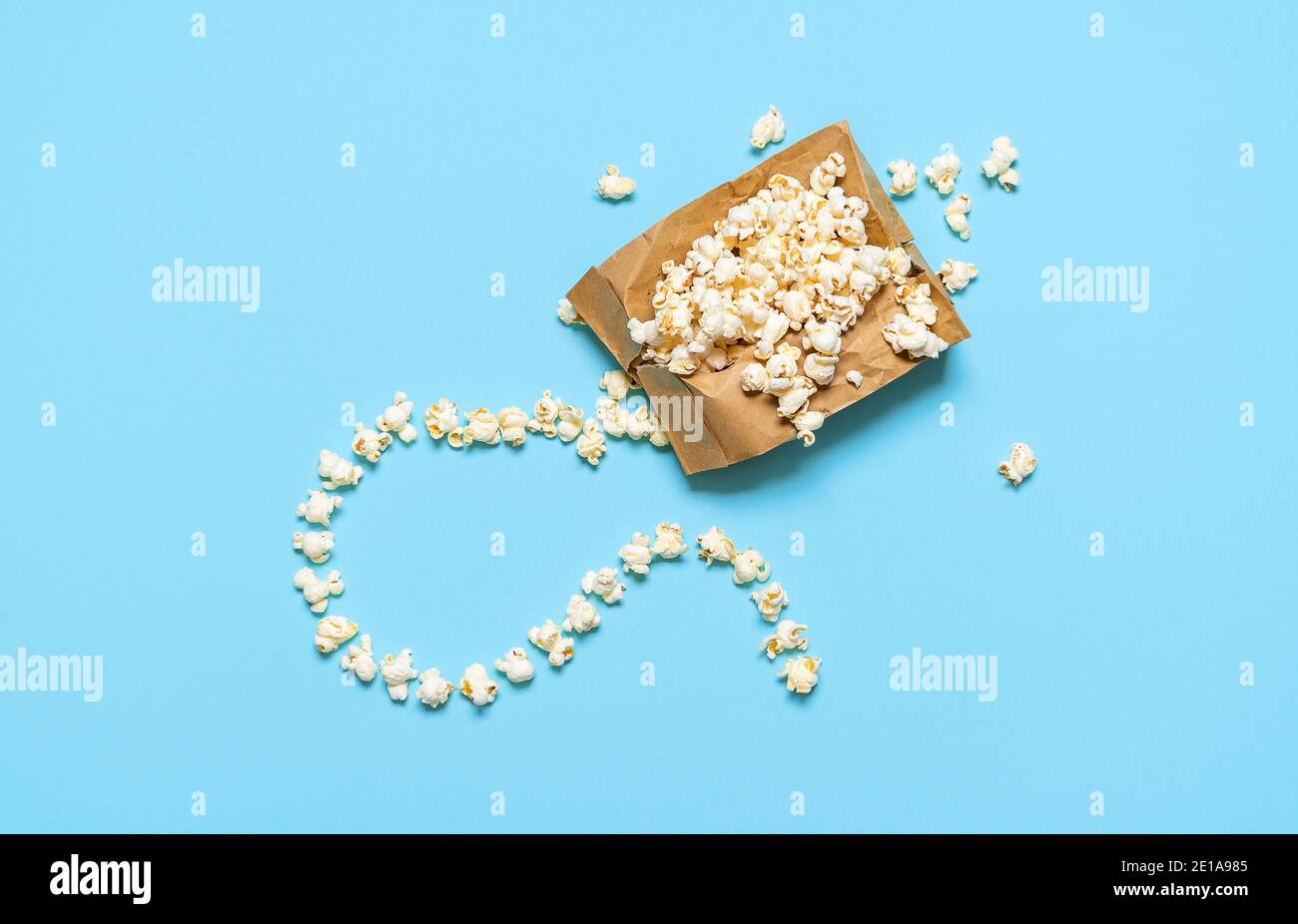 Popcorn exploding in paper bag with fuse, isolated on blue background. Flat  lay with popcorn bag, homemade. Microwave pop-corn bag. Movie time concept  Stock Photo - Alamy