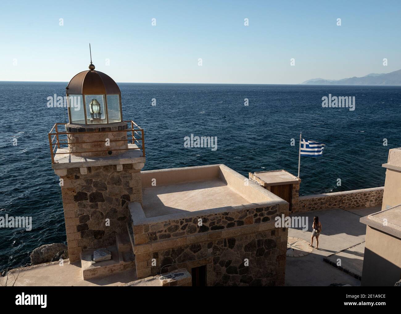 A woman walks next to the lighthouse of Monemvasia, Peloponnese, Greece Stock Photo