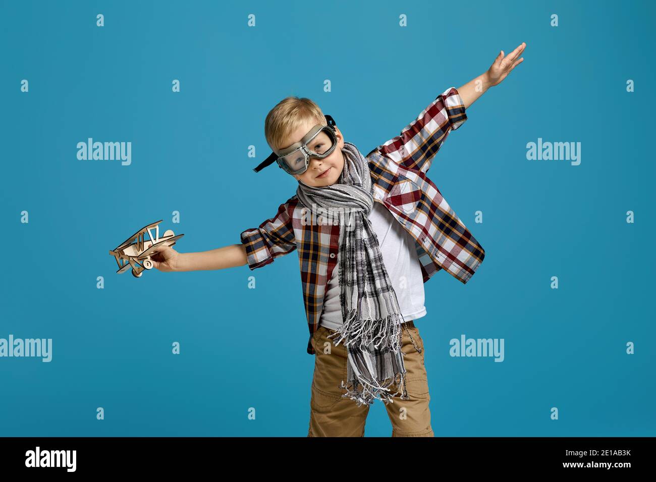 happy child boy in retro glasses and scarf playing with wooden toy ...