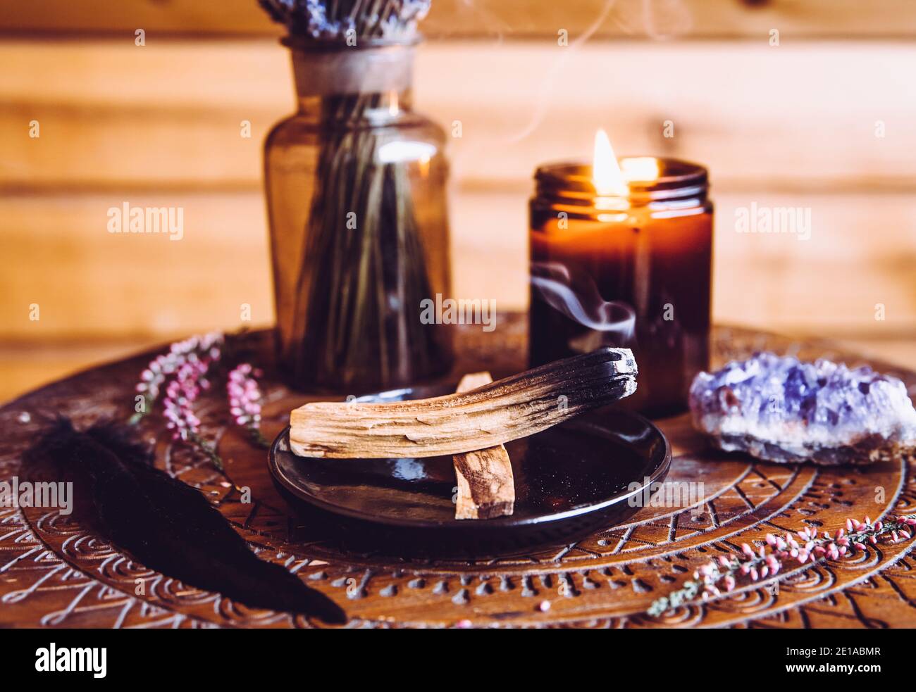 Palo Santo wood known as oily aromatic holy wood sticks smouldering on plate in home living room cleansing negative energy concept. Bohemian style. Stock Photo