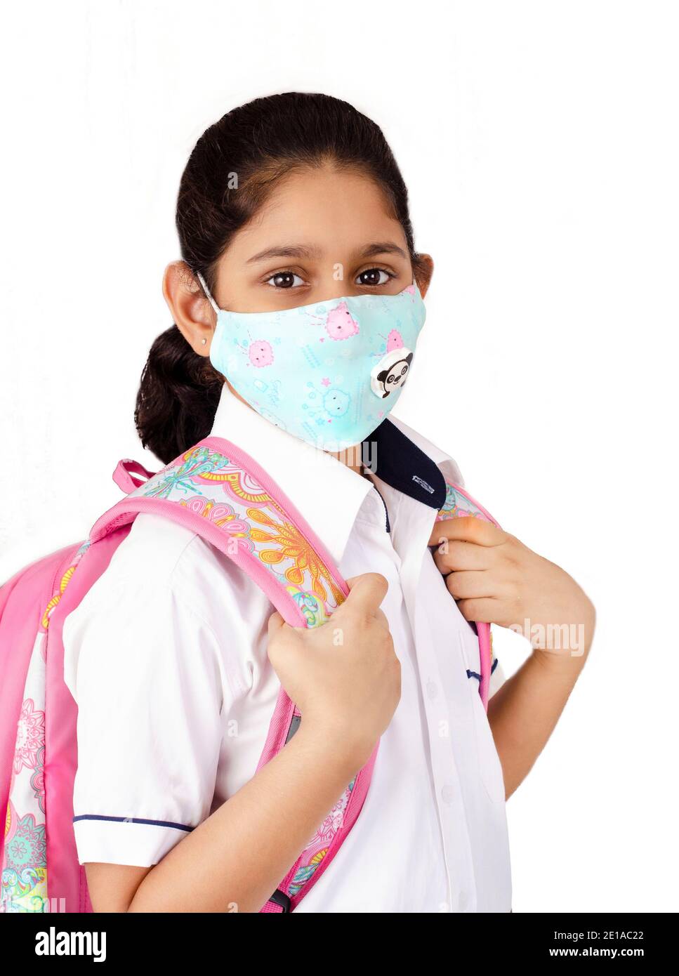 Smiling and happy Indian Child in school unifrom with face mask and school bag, going back to school after covid-19 quarantine and lockdown. Stock Photo