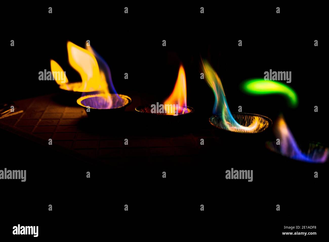 chemical experiment with fire. multi-colored flames in the dark. Stock Photo
