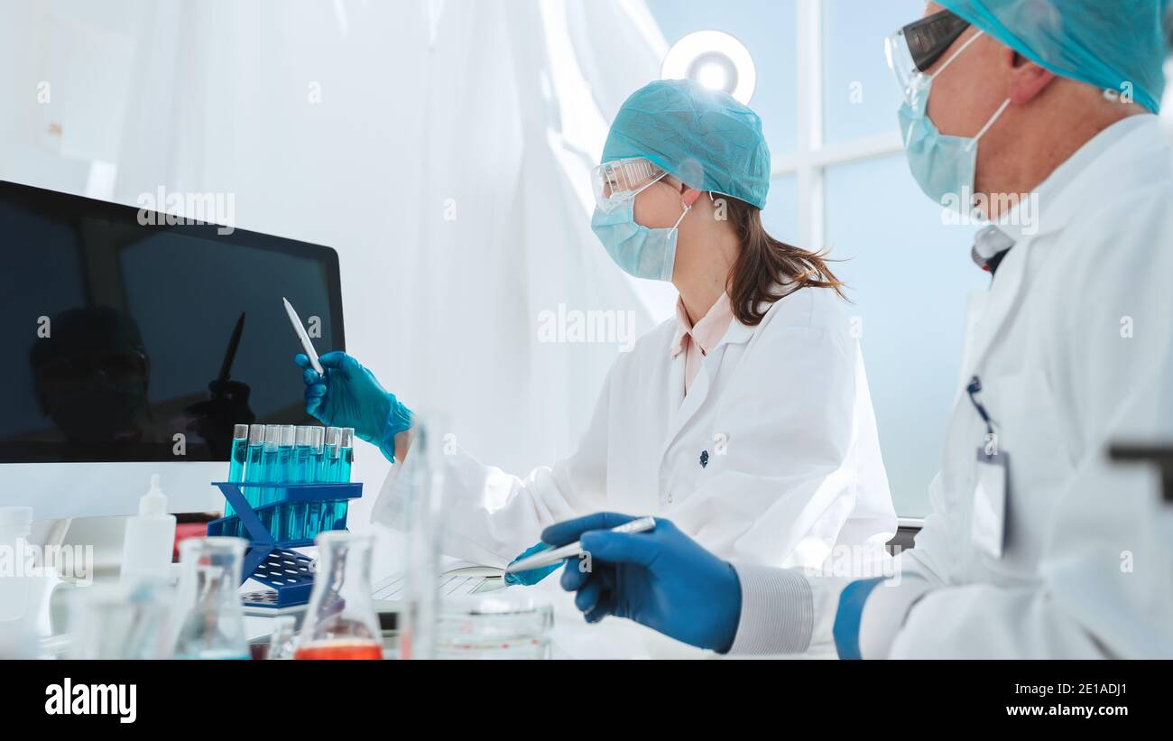 group of scientists looking at a computer screen in the laboratory ...