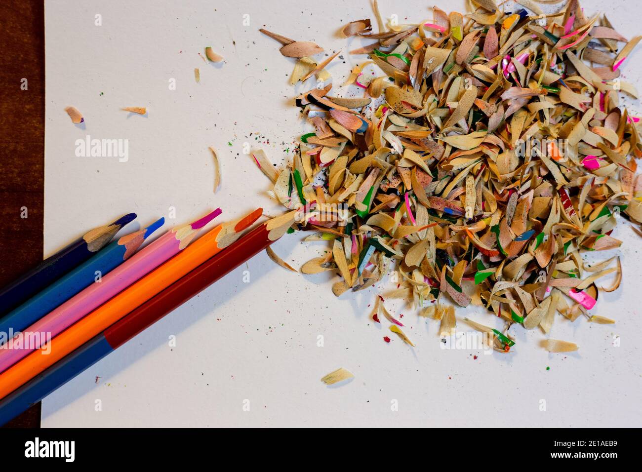 Colored pencils and shavings after sharpening pencils on a white sheet Stock Photo